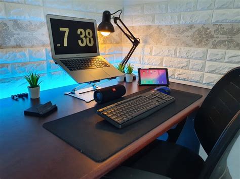 a laptop computer sitting on top of a wooden desk next to a keyboard and mouse