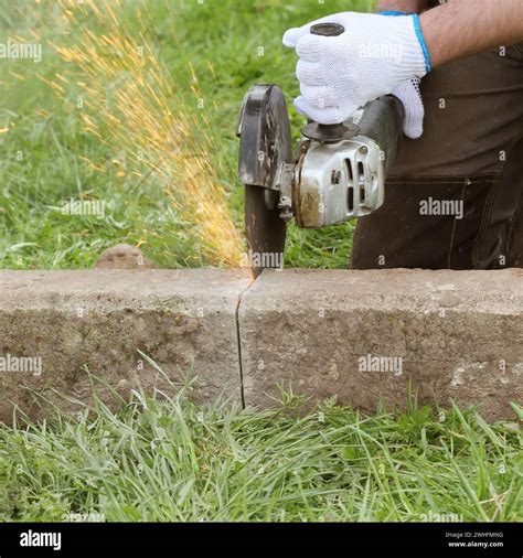 Construction worker cutting concrete plate for fence foundation using a cut-off saw Stock Photo ...