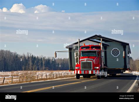 A tractor trailer truck moving a house Stock Photo - Alamy