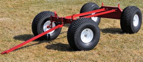 a red trailer with two large wheels on the grass