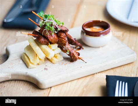 Anticucho Beef skewers with Yuka fries and tari sauce are shown on a table in a restaurant Stock ...