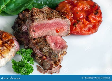 Steak with Blood Medium Rare with a Side Dish of Tomatoes and Vegetables with Spinach Sauteed in ...