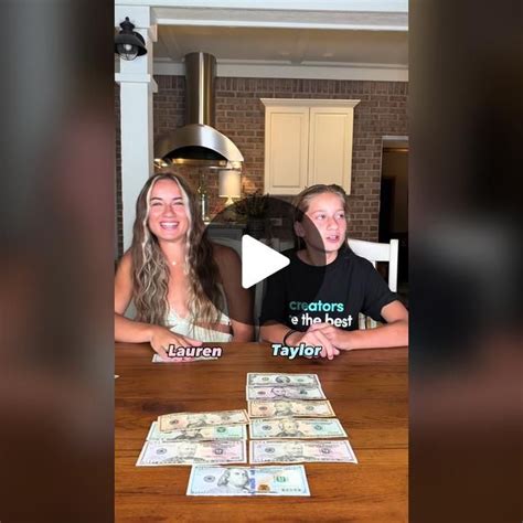 two girls sitting at a table with stacks of money