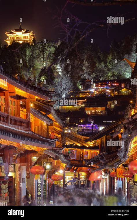 Busy Lijiang Old Town, UNESCO World Heritage Site, at night with Lion Hill and Wan Gu Tower ...