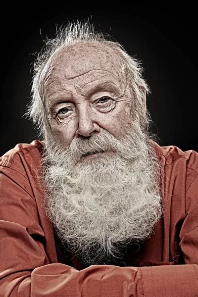 Old age concept. Portrait of an old man with white beard calmly looking at camera. Black ...