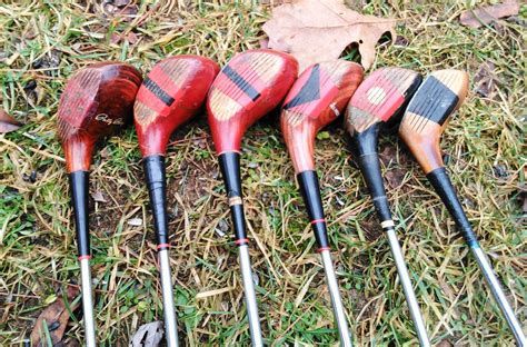 five different types of golf clubs laying on the ground next to some leaves and grass