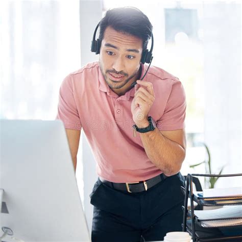 Serious Asian Man, Call Center and Computer in Customer Service or Desktop Support at Office ...