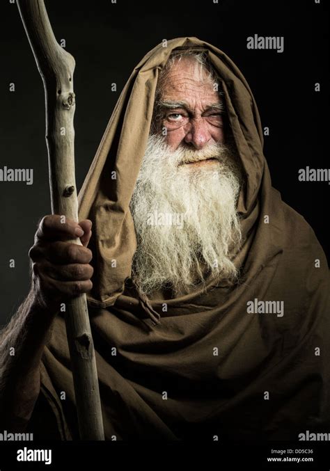 old man with white beard staff and cloak looks like wizard / Gandalf ...