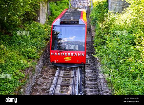 Interlaken, Switzerland - July 16 2019: Red cable car driving downhill ...