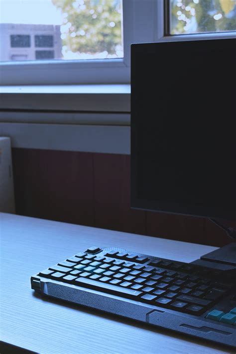 Close-up Photo of Desktop Monitor and Keyboard on Wooden Desk by Window · Free Stock Photo