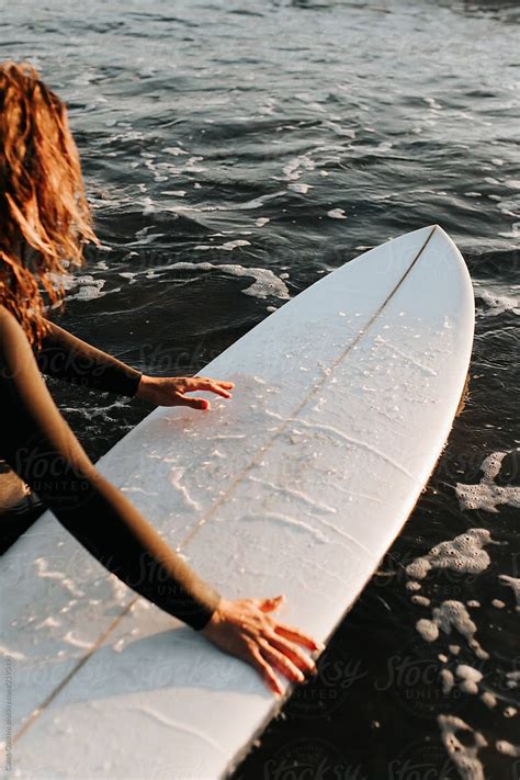 a woman holding a surfboard in the water