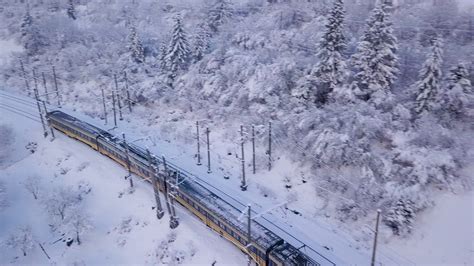 Aerial view of the train going through the mountainous terrain in winter Stock Video Footage 00: ...