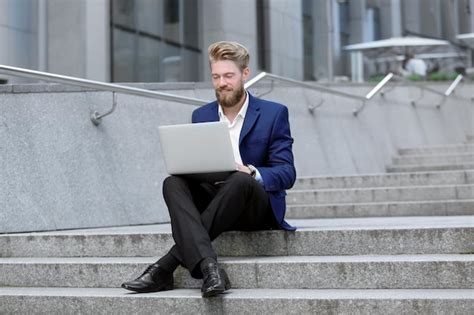 Premium Photo | Handsome young man with laptop outdoors