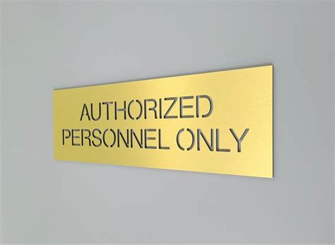 a gold sign that says authorized personnel only