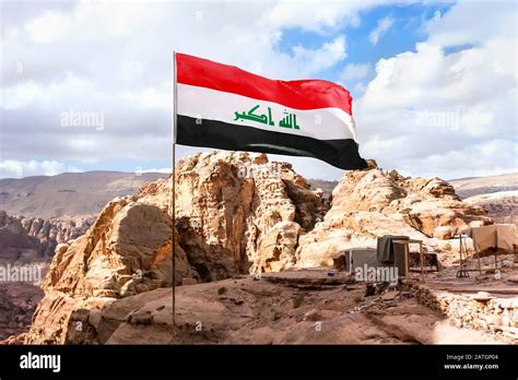 Flag of Islamic republic of Iraq waving in mountain background and ...