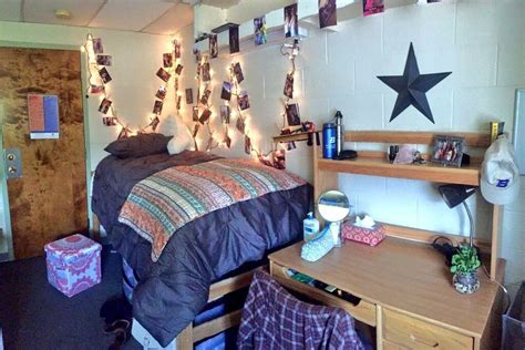 a dorm room with lights strung from the ceiling and decorations on the wall above it