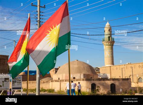 Iraq, Kurdistan, Erbil, The Citadel, Men walking past mosque and Kurdish flag Stock Photo - Alamy