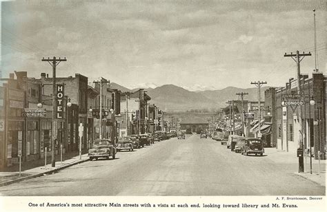 an old black and white photo of cars driving down the street