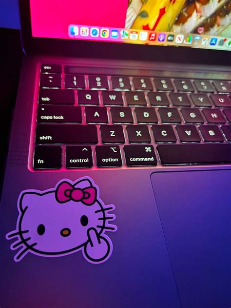 an open laptop computer with a hello kitty sticker on the keyboard