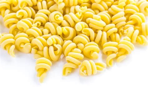 Premium Photo | Organic yellow italian trottole pasta on a white background.