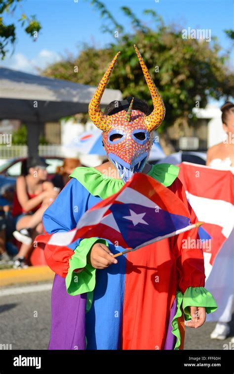 Traditional cultural figure VEJIGANTE posing with flag during the carnival in Ponce. Puerto Rico ...