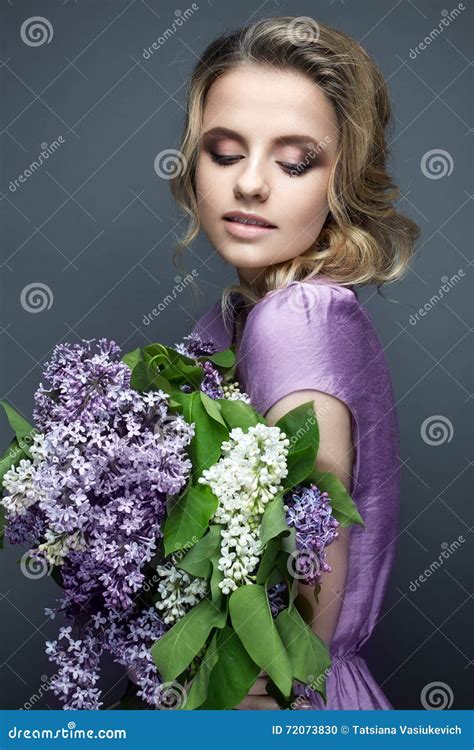 Beautiful Girl in a Purple Dress and a Bouquet of Lilacs. the Model is in an Image of Spring ...