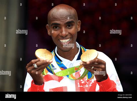 Great Britain's Mo Farah with his gold medals for victory in the Men's 5000m and 10000m during a ...