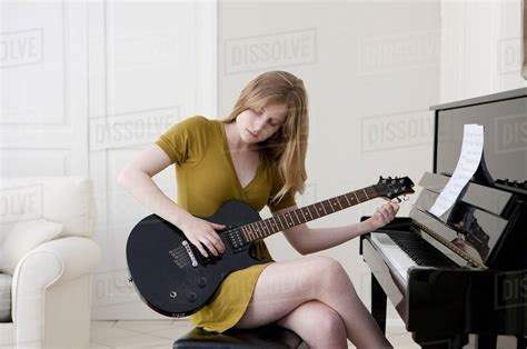 Teenage girl playing electric guitar - Stock Photo - Dissolve