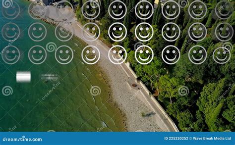 Digital Composition of Rows of Multiple Smiling Face Emojis Against Aerial View of the Beach ...
