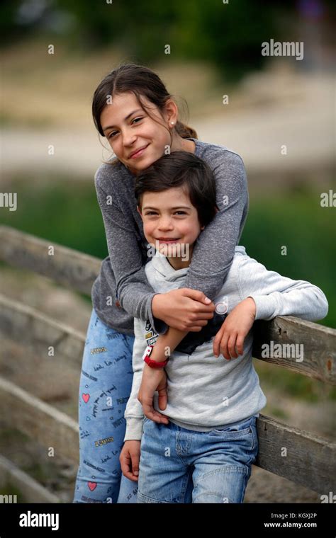 Sister giving her younger brother a hug Stock Photo - Alamy