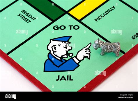 A dog piece on the Go to Jail space on a monopoly game board UK Stock Photo - Alamy