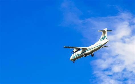 Puerto Escondido Oaxaca Mexico 2022 Plane flies over Puerto Escondido Mexico with blue sky ...