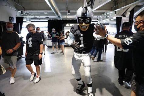 Raiders’ NFL mascot Raider Rusher high fives fans while walking the ...