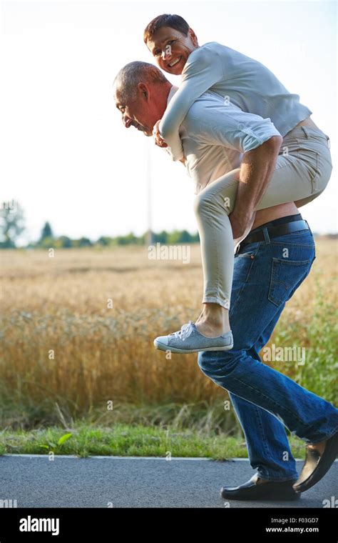 Old man giving woman piggyback ride on his back in summer Stock Photo, Royalty Free Image ...