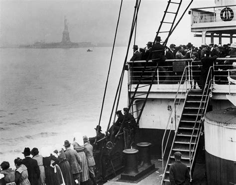 Immigrants view the Statue of Liberty from an ocean liner as they ...