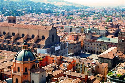 an aerial view of a city with buildings and mountains in the backgrouds