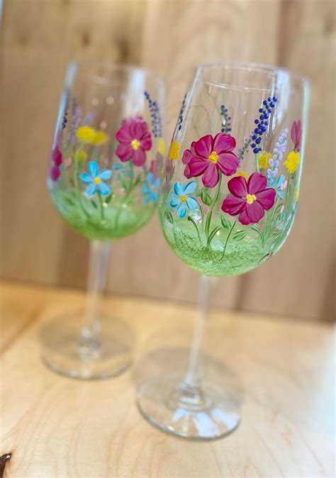 two wine glasses with flowers painted on them