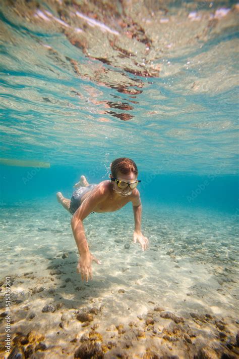 Boy swimming underwater Stock Photo | Adobe Stock