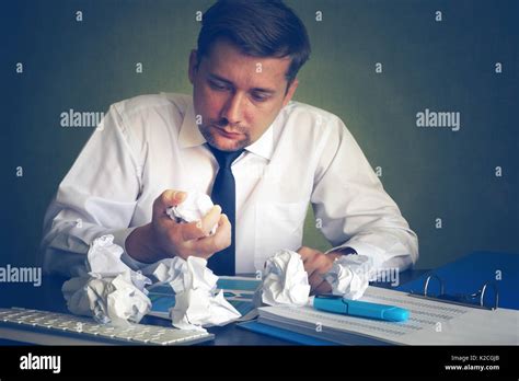 Man looking on a crumpled office paper in an office. Businessman with stress Stock Photo - Alamy