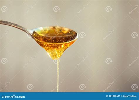 Honey Dripping from the Spoon. Golden Liquid in the Spoon Stock Image ...