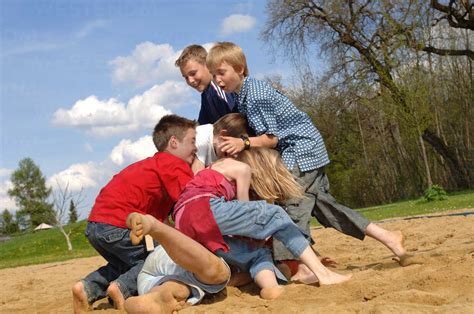 Children (6-9) play fighting on playground stock photo