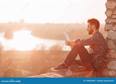 Young Man Reading a Book Outdoors Stock Photo - Image of casual ...