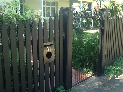 a black fence with a house in the background and a bicycle on it's side