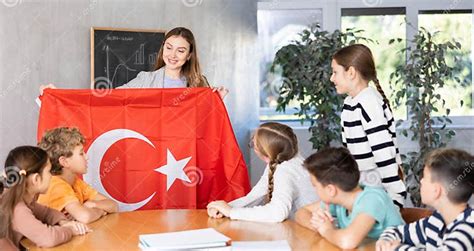 Female Teacher Working with Teenage Students in School Class, Talking about National Flag of ...