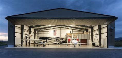 an airplane is parked in the garage with its doors open and it's lights on