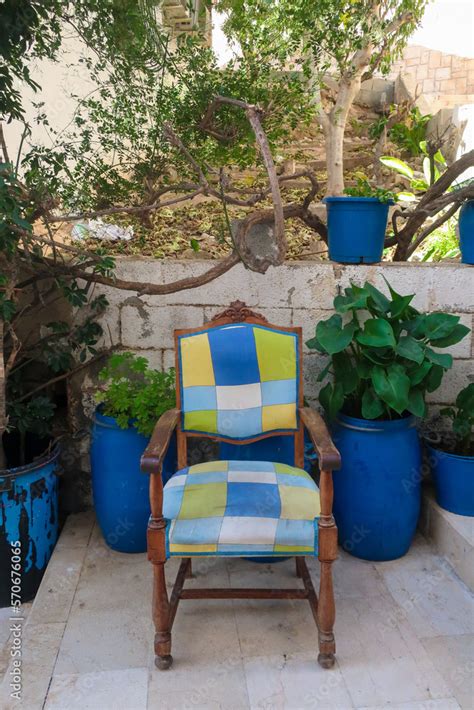 Old chair with block pattern in blue, green, yellow in street in barrio ...