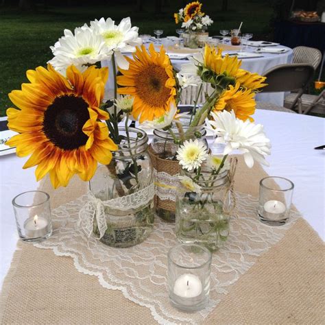 Daisies and sunflowers in mason jars. Burlap and lace. Table setting ...