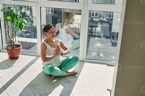 Mindful woman performing padmasana, inhaling air and doing breathing ...