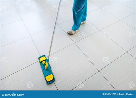 Floor Washing in the Mall. a Woman is Cleaning Tiles in a Large Room ...