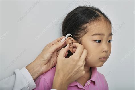 Fitting hearing aid - Stock Image - F037/0904 - Science Photo Library